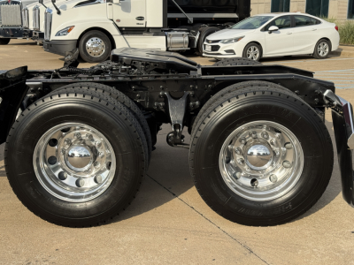 Dual rear wheels on a truck chassis showing polished chrome rims and black suspension components.