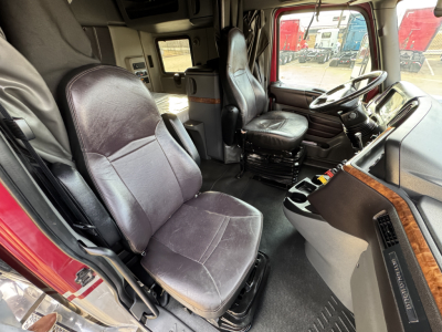 Truck cab interior of a 2021 International Lonestar showing driver seat and passenger seat with dashboard and steering wheel visible.