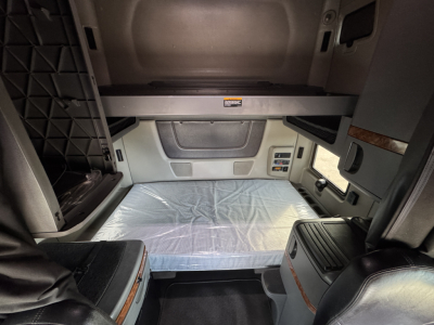 Interior cab view of a 2021 International Lonestar sleeper cab showing seating area and dashboard panels with storage compartments.