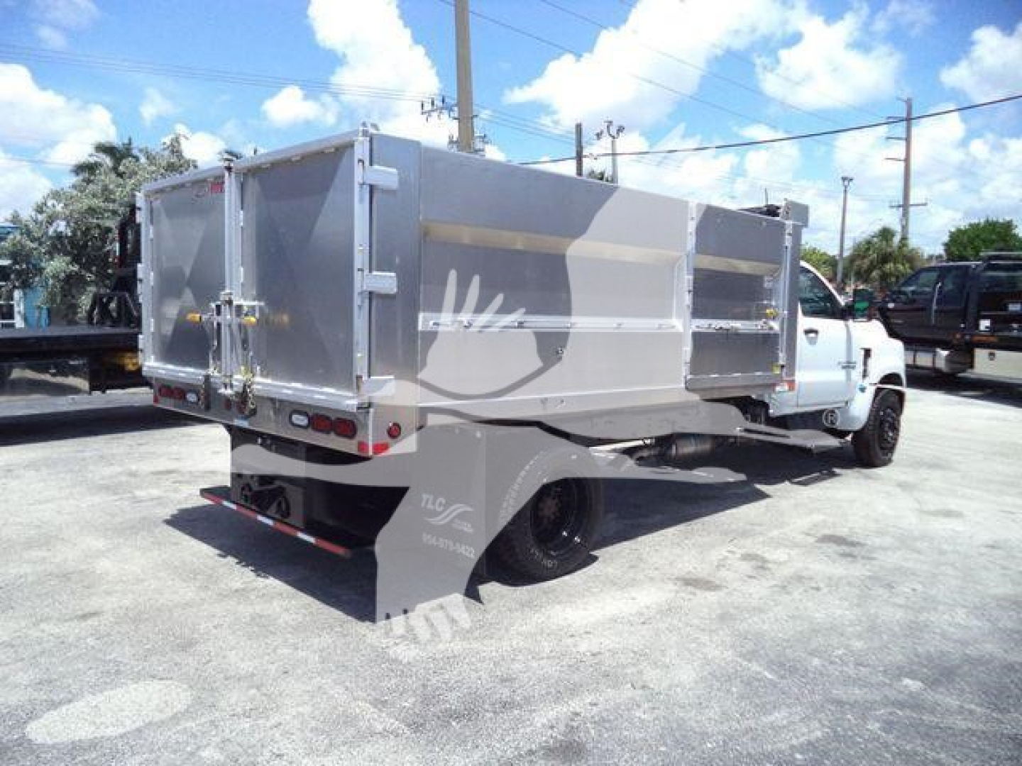 Dump truck bed of a 2023 Chevrolet Silverado 6500HD with aluminum dump body and dual rear wheels, side view.