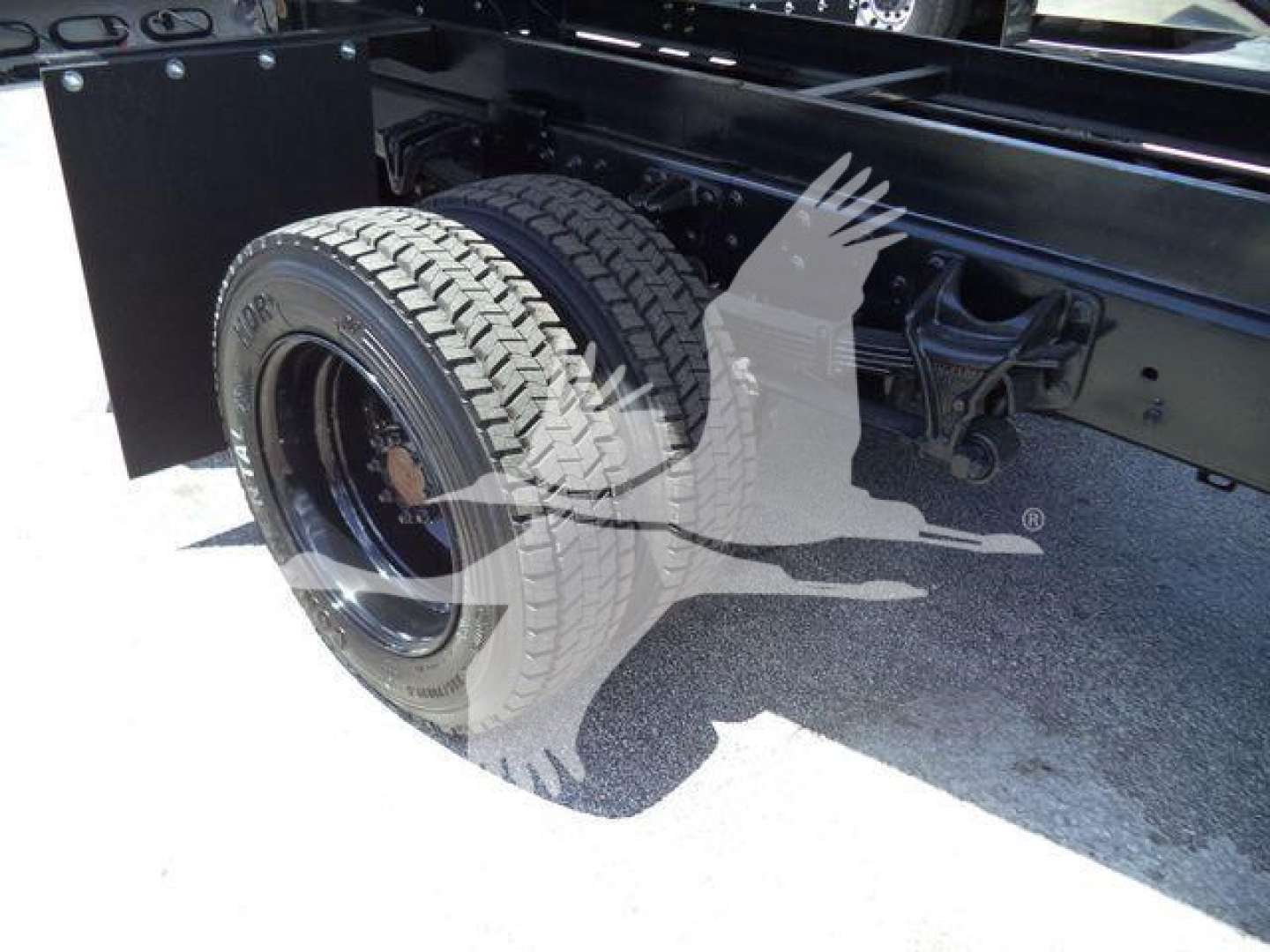 Truck rear wheel assembly of a 2023 Chevrolet Silverado 6500HD dump truck showing dual rear tires and chassis components.