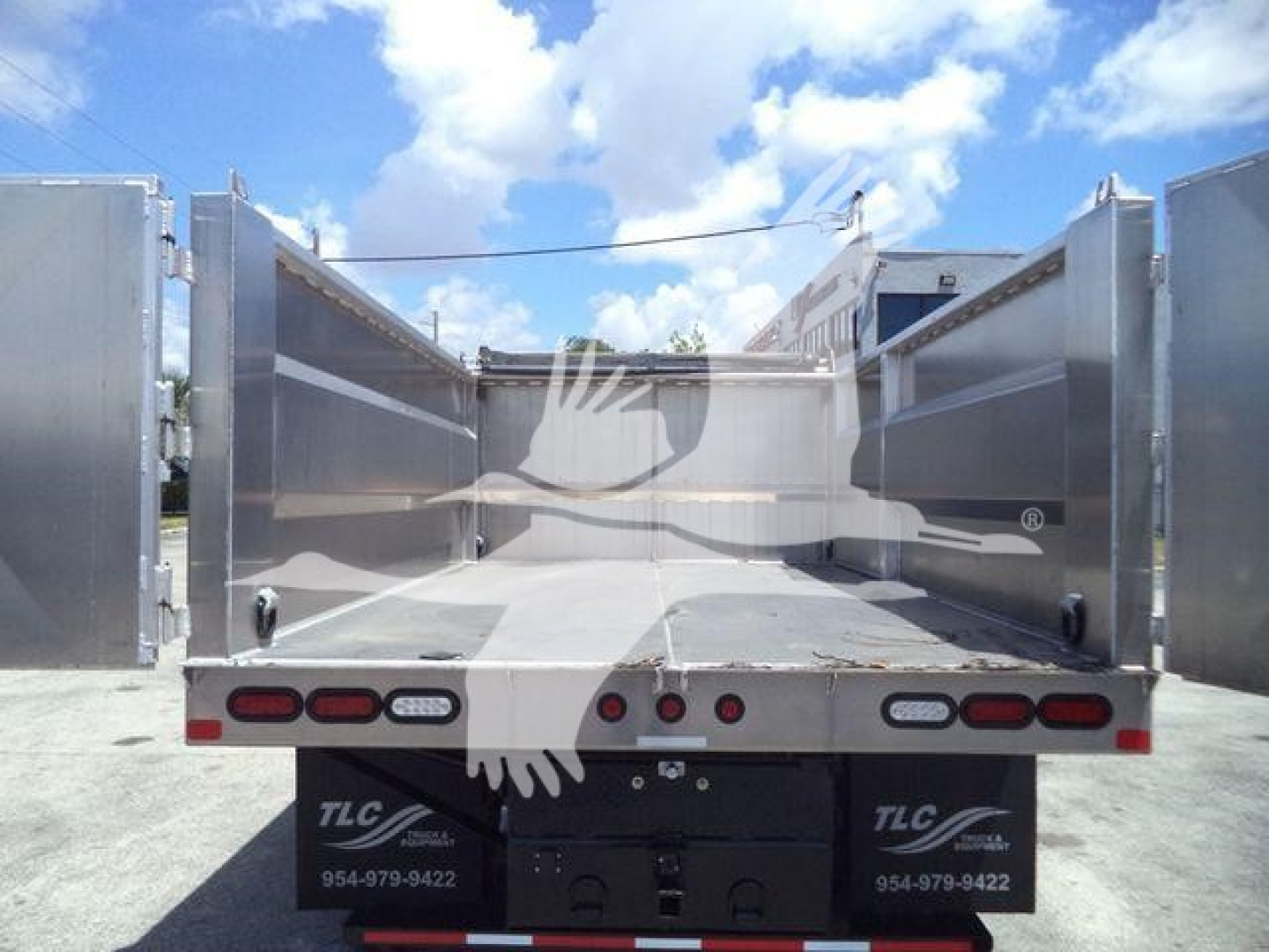 Dump bed of a 2023 Chevrolet Silverado 6500HD truck in a flatbed configuration, open cargo area with metallic sidewalls and tail lights visible.