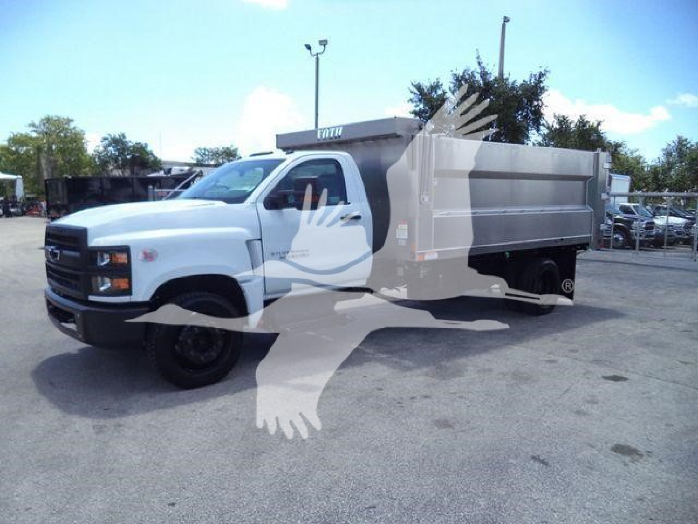Chevrolet Silverado 6500HD dump truck in white with aluminum dump body, side view.