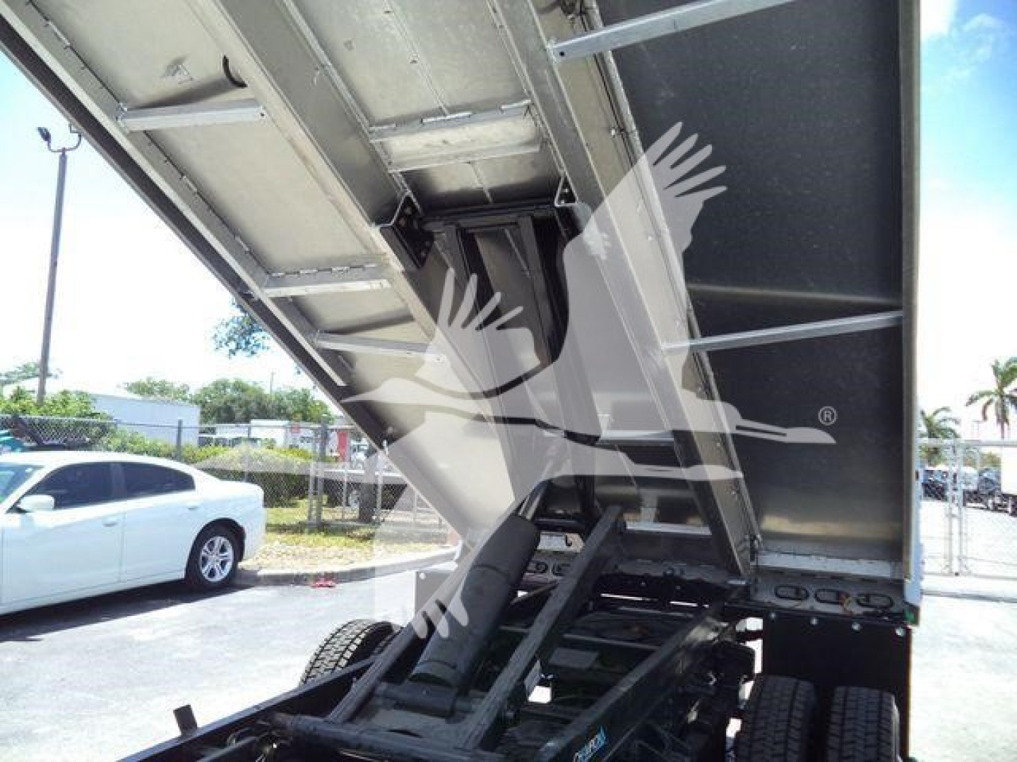 Dump bed chassis of a 2023 Chevrolet Silverado 6500HD dump truck in a raised position; visible hydraulic cylinders and frame with side rails.