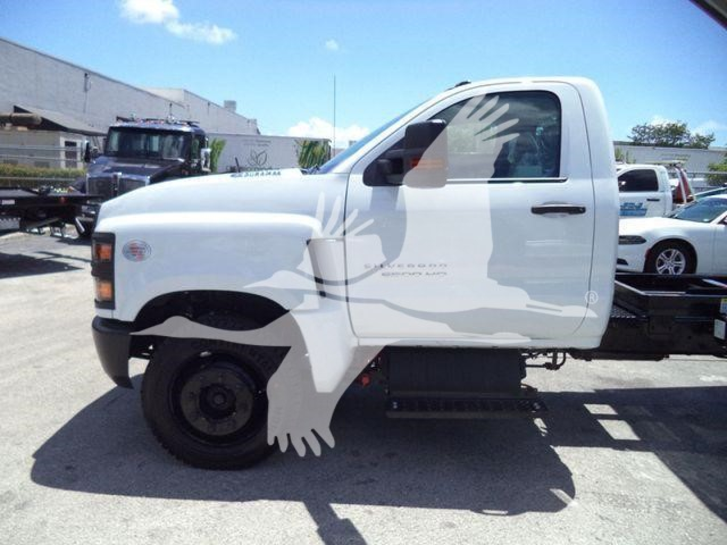 Chevrolet Silverado 6500HD dump truck cab side view with white body and black front fender, single cab, no bed, stock number 6500ALUMDMP visible in listing