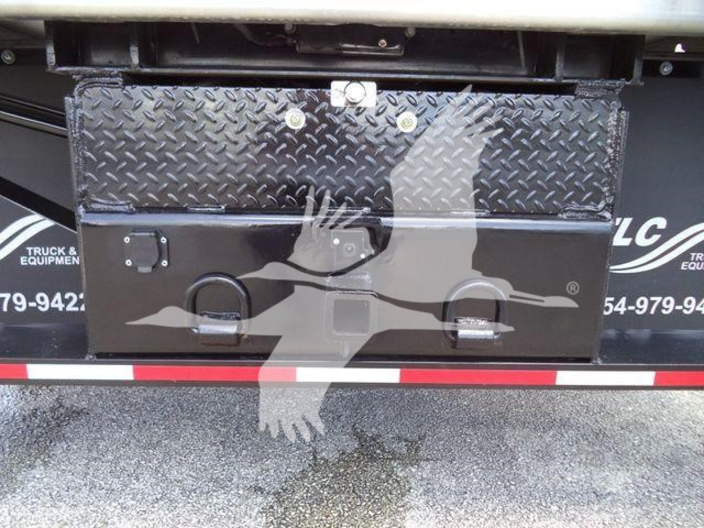 Truck bed toolbox mounted on a Chevrolet Silverado 6500HD dump truck showing a diamond plate toolbox with latches and a cracked open area.
