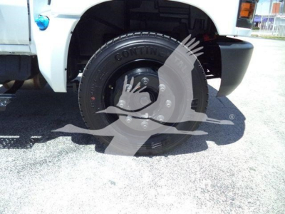 Front left wheel and tire of a 2023 Chevrolet Silverado 6500HD dump truck showing Continental tire and wheel assembly.