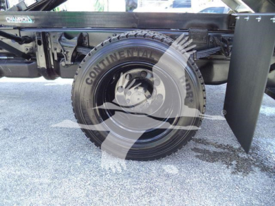 Truck wheel and suspension components of a 2023 Chevrolet Silverado 6500HD dump truck showing Continental tire and undercarriage details.