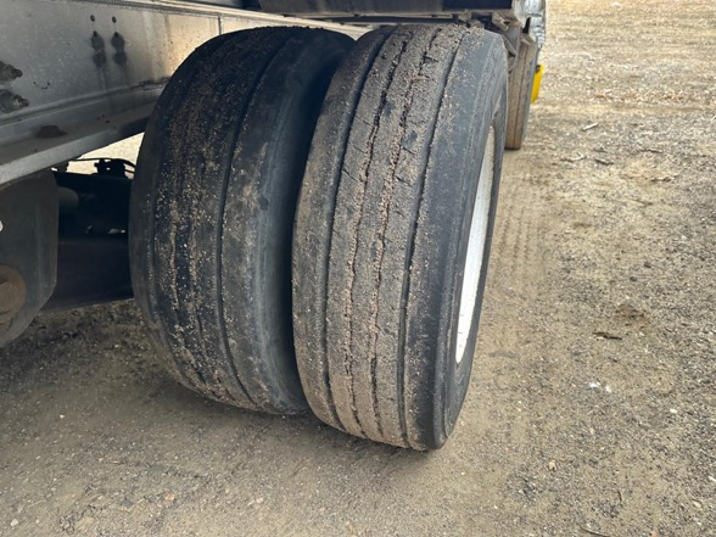 All-aluminum Trail King air-ride drop deck trailer wheel pair showing dual tires and part of the trailer frame.