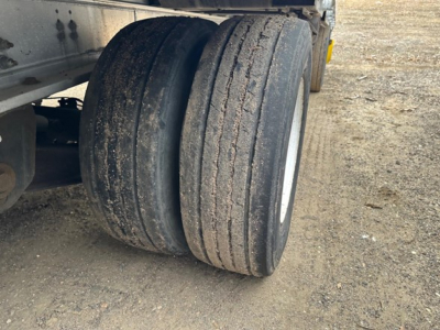 All-aluminum Trail King air-ride drop deck trailer wheel pair showing dual tires and part of the trailer frame.