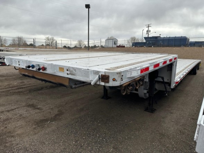 Flatbed trailer show a drop deck design with aluminum construction and air ride system.