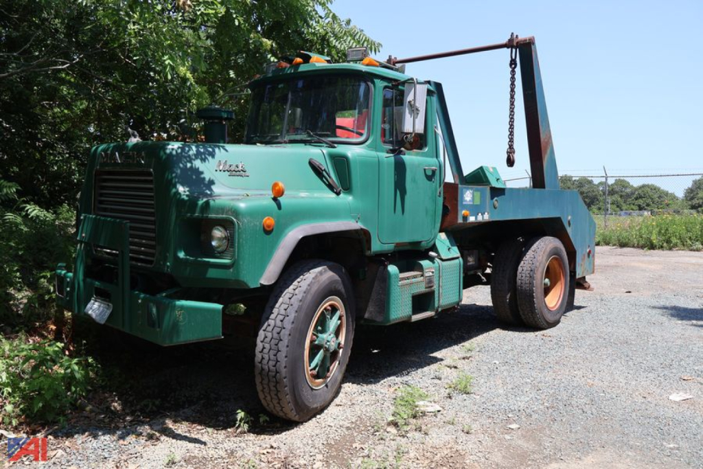 1994 Mack DM688X truck in green with winch equipment and tow arm, front view showing cab and wheels.