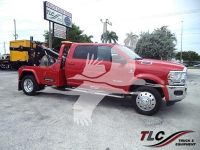 Ram pickup truck in red with winch equipment mounted, side view showing extended cab and branding
