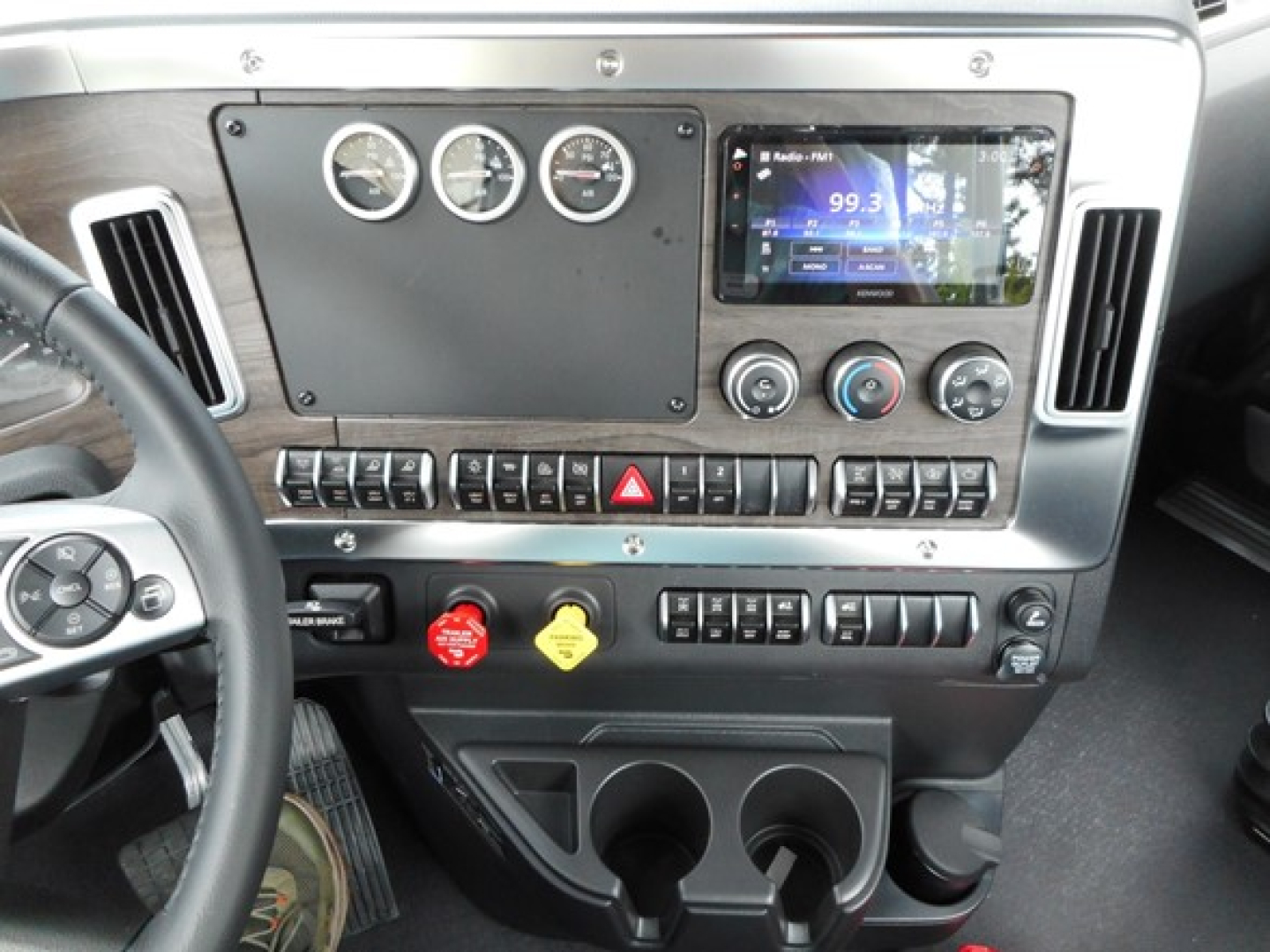 Dashboard of a 2026 Western Star 49X day cab showing instrument gauges, infotainment display, climate controls, and center stack with switches and cup holders.