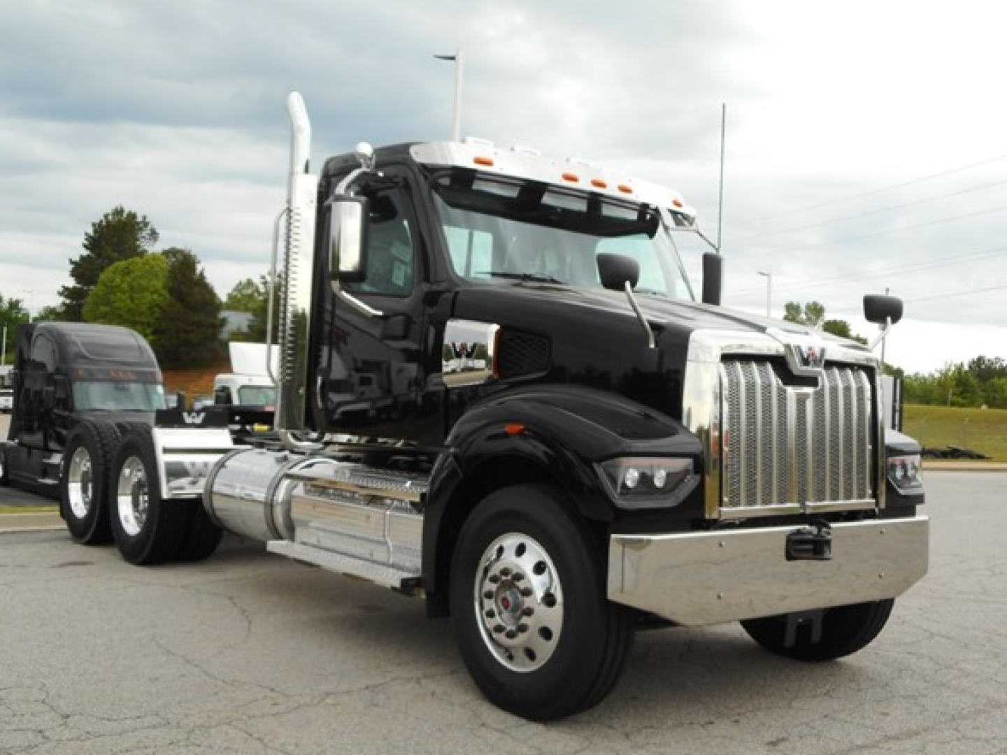 Western Star 49X day cab truck in black with chrome grille and dual exhaust stacks, front view, chrome bumper, chrome fuel tanks.