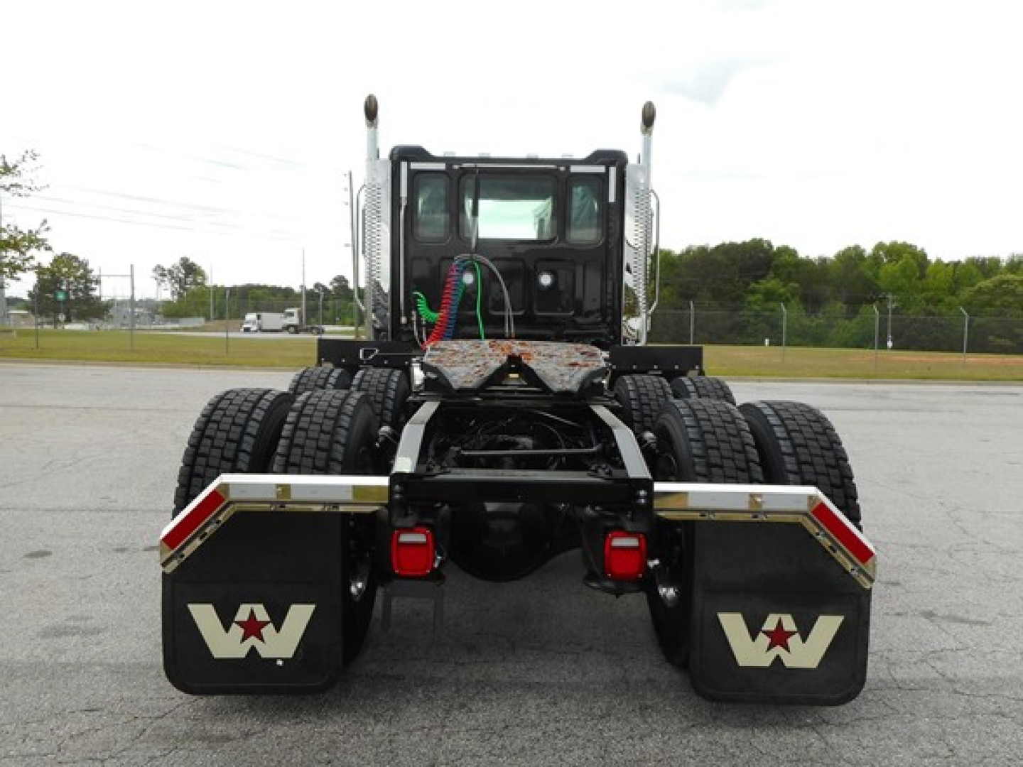 Western Star 49X rear view showing dual rear axles, fifth wheel, and mudflaps with Western Star logo.