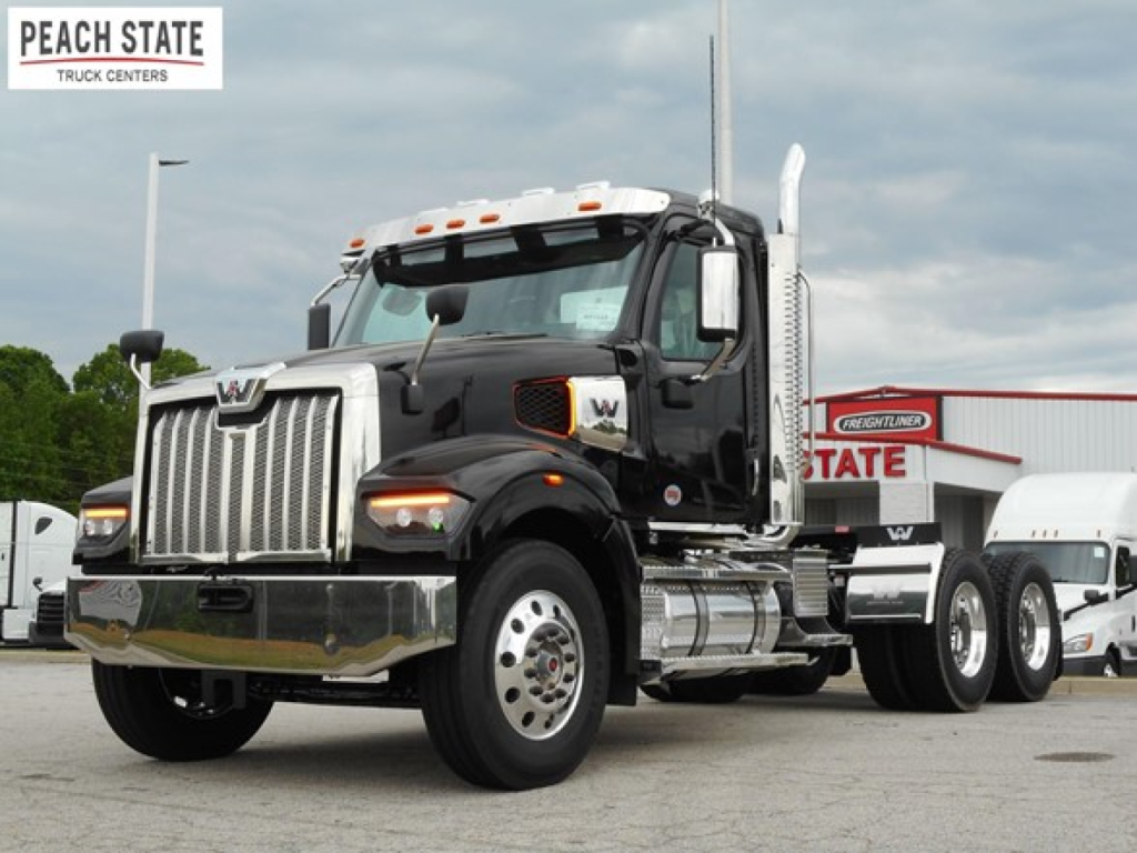Western Star 49X day cab truck in a dealership lot with chrome exhaust stack and large grille, Peach State Truck Centers logo on image.