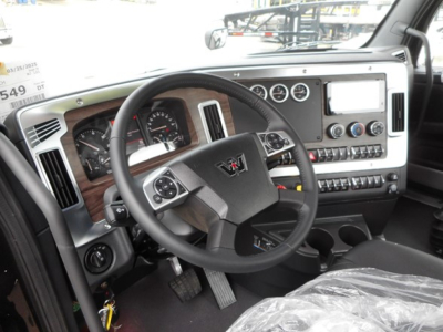 Interior of a Western Star 49X truck cab showing steering wheel, dashboard gauges, and center console with touchscreen and controls.
