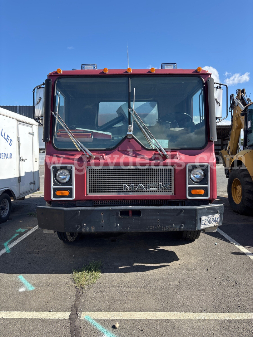 Front view of a red Mack MR685P dump truck showing grille with MAC K logo, large bumper, two square headlights, windshield wipers, and side mirrors.