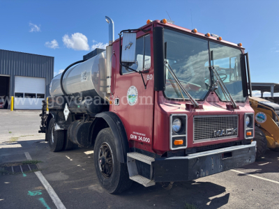 Mack MR685P tank truck in red, front-side view showing cab details and tank behind. Visible text includes Mack emblem on grille and numbers on door.