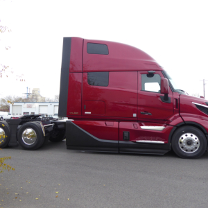 Volvo VNL sleeper cab tractor side view showing aerodynamic mirror, window, and rear dual tires; no legible text visible on cab panels.
