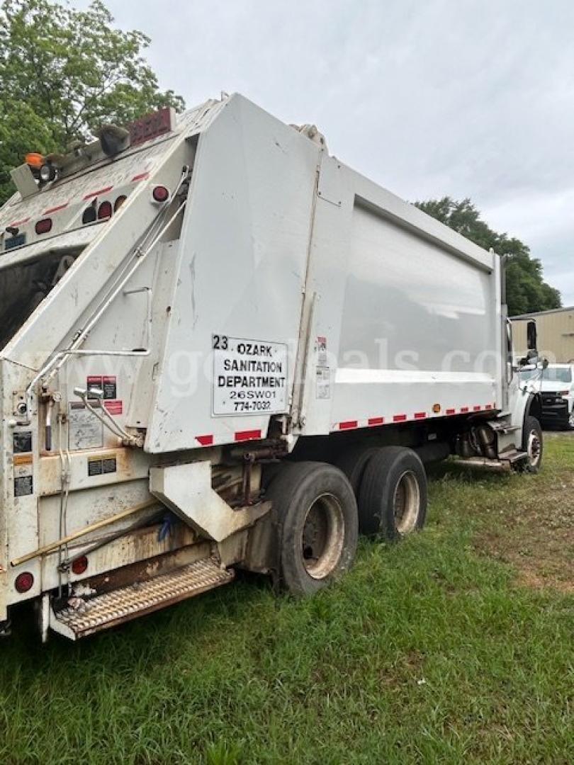 Freightliner M2 106 side rear view showing dump bed and wheels, white truck with red/white reflective tape, stock number 146-377.