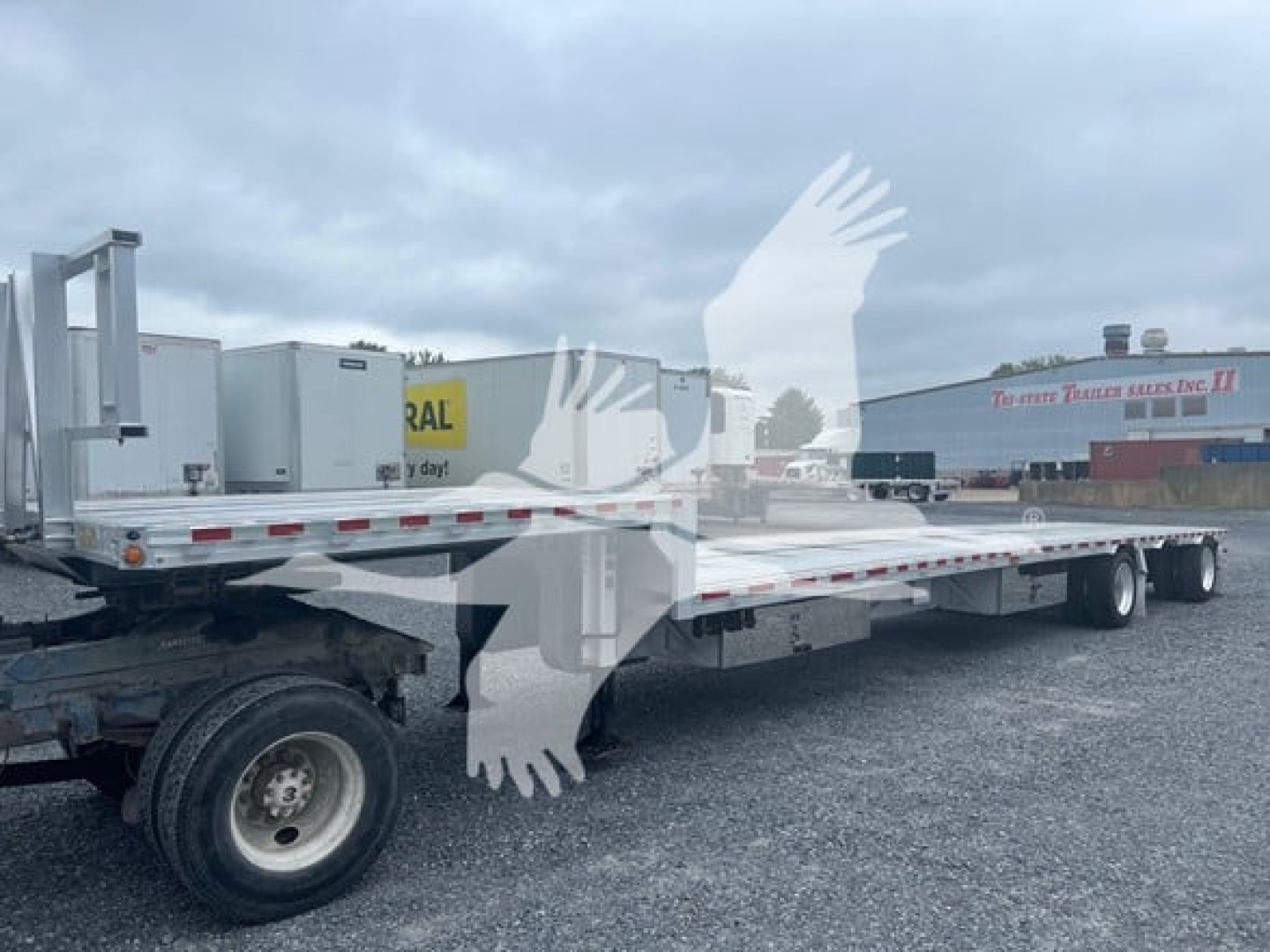 2018 Reitnouer Dropmiser flatbed trailer showing long deck and tandem axles.