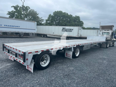 Trailer deck of a 2018 Reitnouer Dropmiser with flatbed, dual rear axles, and side marker lights visible.