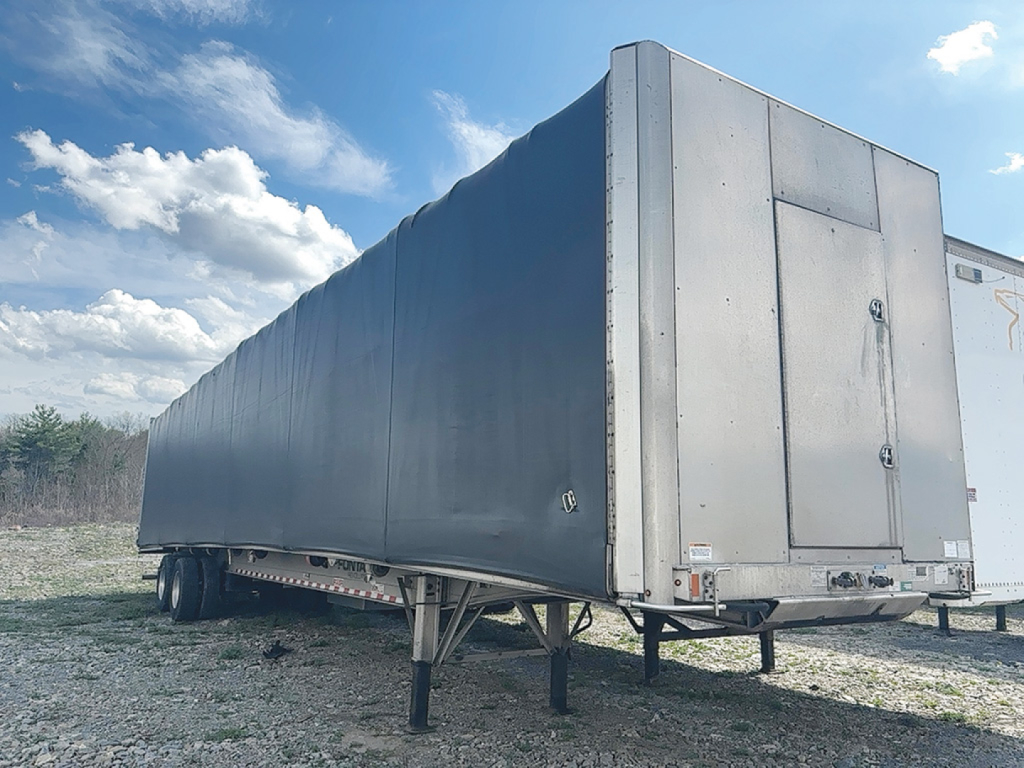 Fontaine Revolution curtainside trailer showing side and rear with gray outer tarp and rear door; VIN N1550282 on listing.