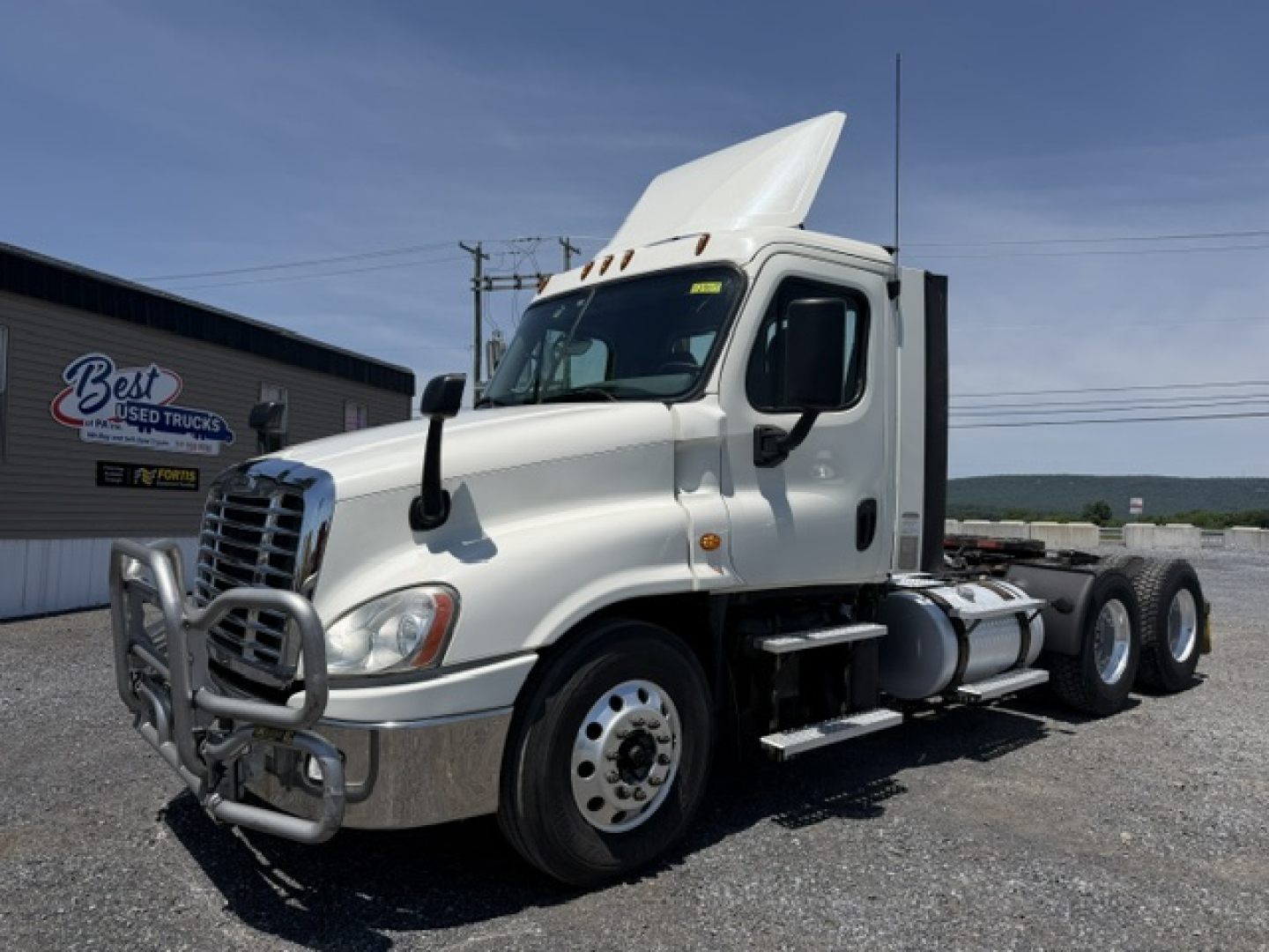 Freightliner Cascadia CA125DC tractor-trailer in profile showing front bumper guard and side fuel tanks.