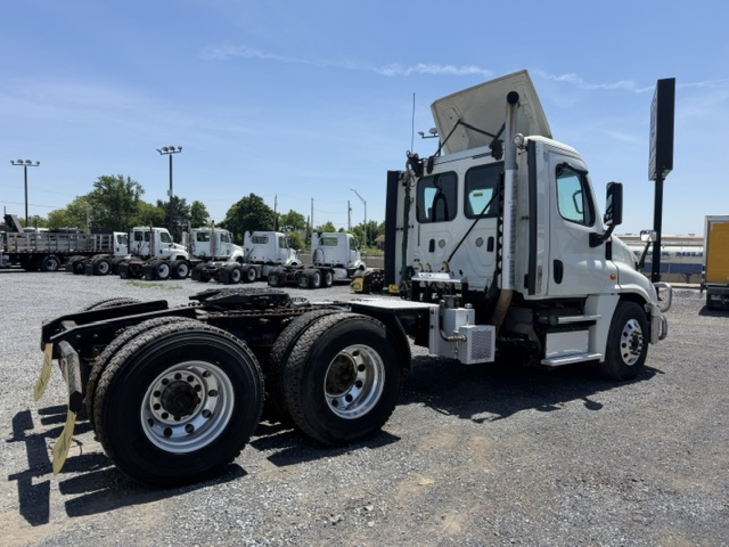 Truck chassis and cab of a 2018 Freightliner Cascadia CA125DC showing rear dual rear axles and open sleeper area, side view