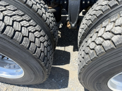 Freightliner Cascadia CA125DC wheel area showing dual rear axles and heavy tread tires.
