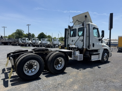 Truck chassis and cab of a 2018 Freightliner Cascadia CA125DC showing rear dual rear axles and open sleeper area, side view