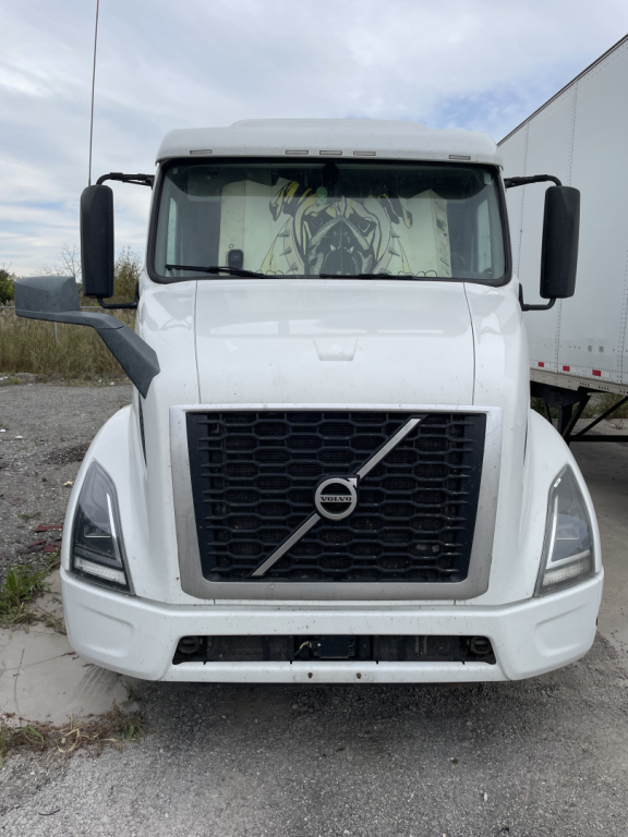 Volvo VNR truck front view showing large black grille with diagonal Volvo emblem and daytime running lights.