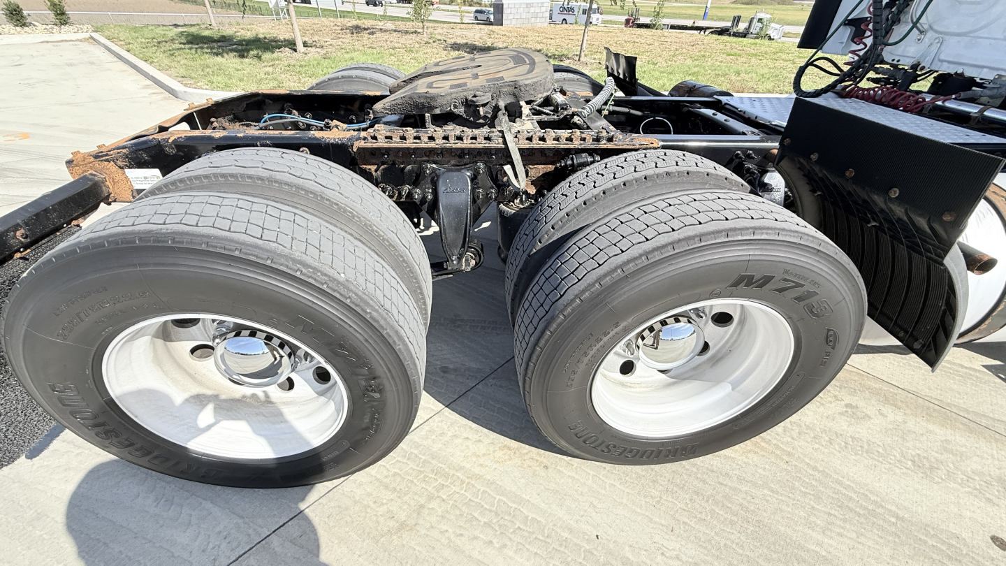 Freightliner CA12564DC chassis with dual rear axles showing tires and undercarriage components.