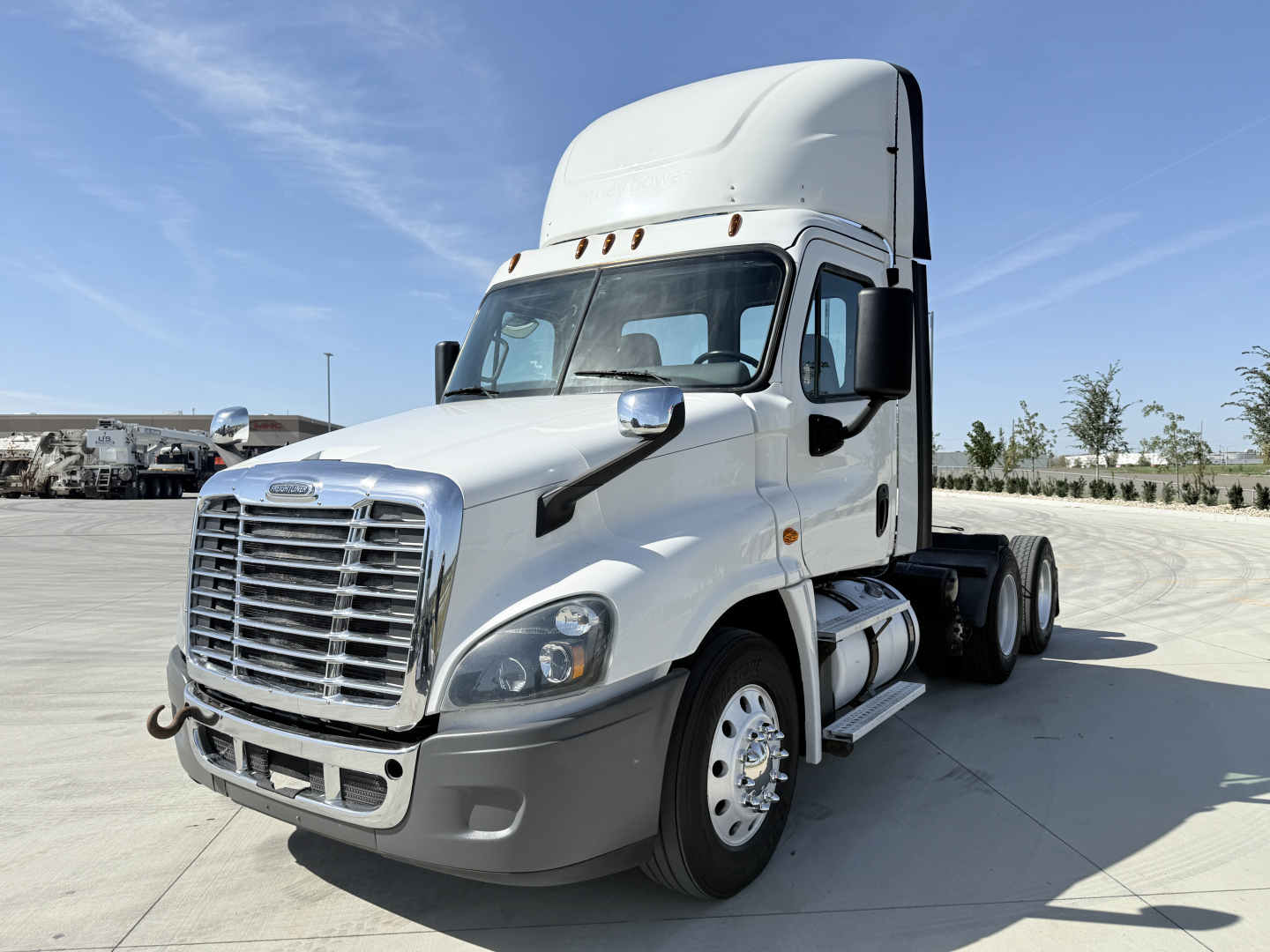 Freightliner CA12564DC conventional daycab tractor in white, front-left view, showing large grille, bumper, headlight cluster, dual rear wheels, and high sleeper cab.