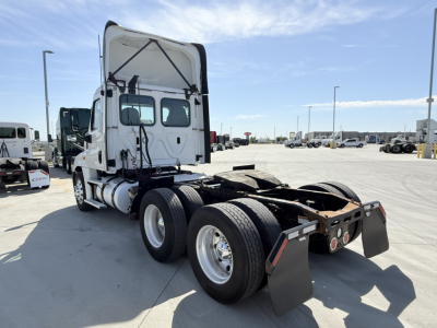 Freightliner CA12564DC tractor rear view showing dual rear axles and fifth-wheel plate with mud flaps.