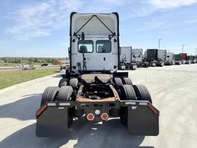 Rear view of a Freightliner tractor with fifth wheel missing, showing dual rear axles and mud flaps.