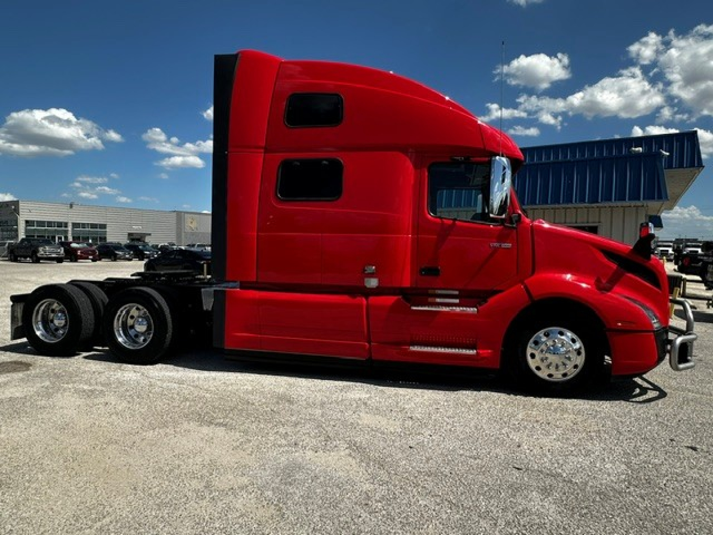 Volvo VNL64T860 sleeper cab tractor in red showing side view with chassis and rear wheels.