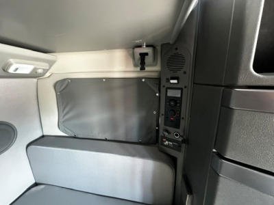 Cab interior side panel with control panel and storage pocket of a 2024 Volvo VNL64T860 sleeper cab.