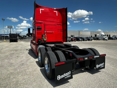 Volvo VNL64T860 rear view showing fifth wheel, dual rear axles, black mud flaps, and red sleeper cab.
