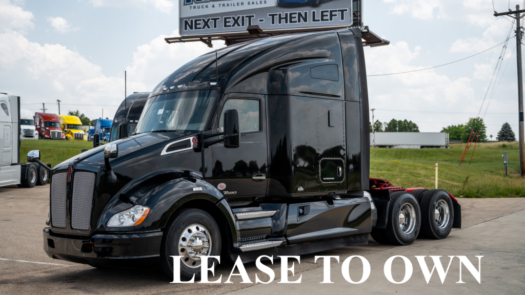 Kenworth T680 tractor-trailer cab in black, side view, with 'LEASE TO OWN' overlay sign on windshield area and a daytime lot background.