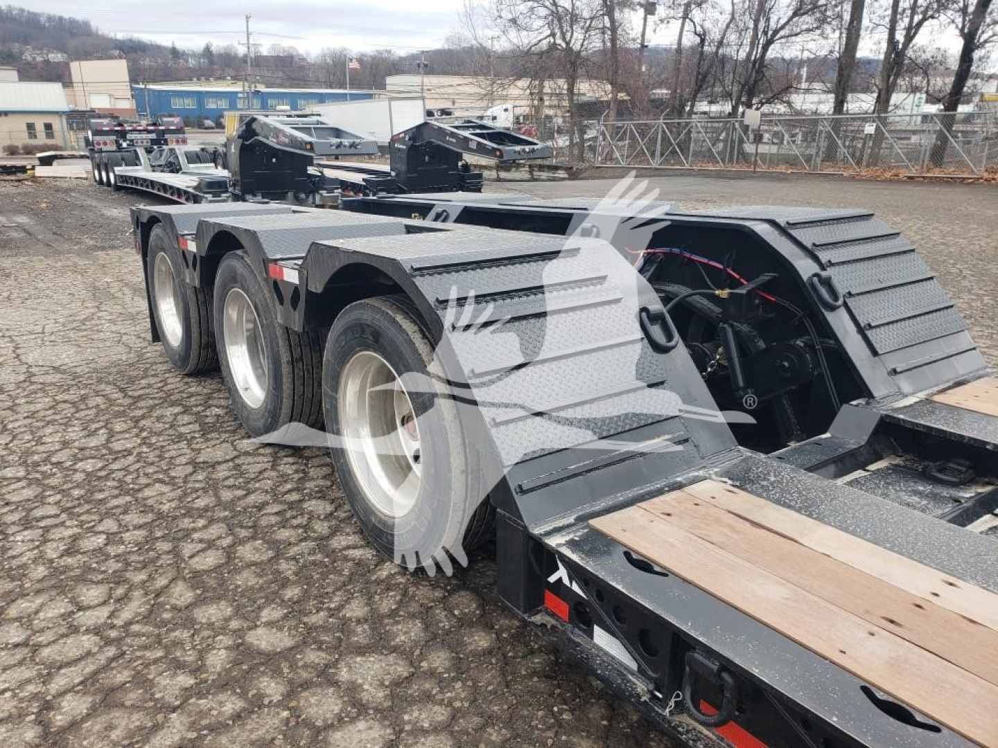 55-ton lowboy trailer deck height with wheel covers and multiple axles visible.