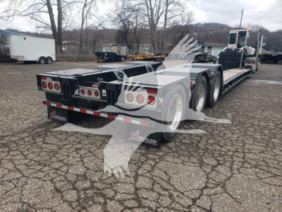 XL Specialized 55 Ton lowboy trailer showing rear and side view with triple-axle configuration and nameplates.