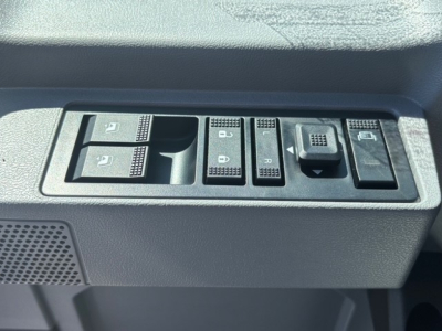 Dashboard window control switches in a Mack GR64F cab showing multiple buttons for window and mirror adjustments.