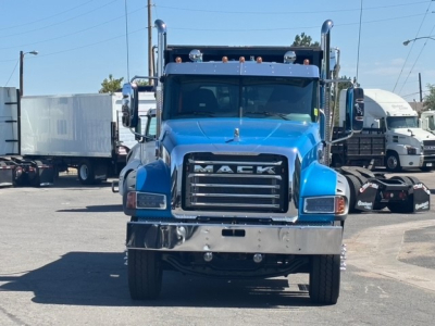 Mack GR64F dump truck front view showing blue cab, large grille with MACK letters, chrome bumper, dual air intake stacks, and headlights.