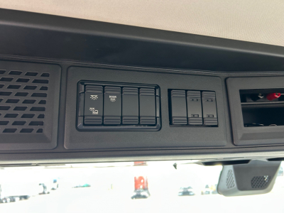 Dash panel with multiple switches and vents in a Mack PR64T truck interior showing labeled control switches and blank panel slots.