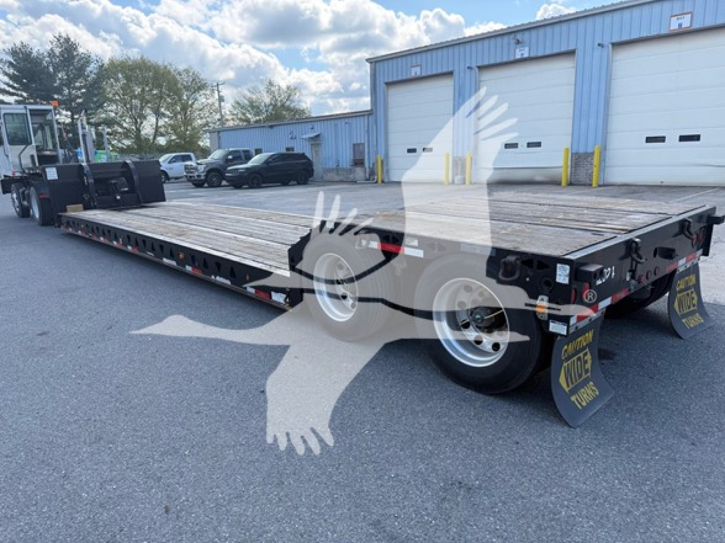 Talbert mechanical detach lowboy trailer from side and rear angles showing flat deck and dual rear axles with mud flaps and loading ramps.