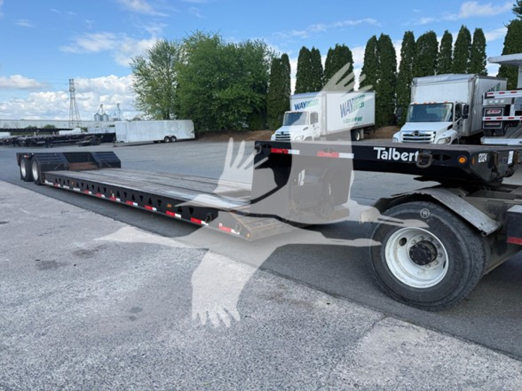 Talbert lowboy trailer with long flatbed and hydraulic detach tongue showing wheel and front cab, 