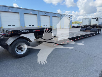 Talbert mechanical detach lowboy trailer showing long flat deck, dual rear axles, and wheel assembly with Talbert branding near front. VIN and stock not visible on deck.